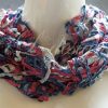Modell mit Loop-Schal in der eleganten Farbkombination aus Dunkelblau, Weinrot und Silbe